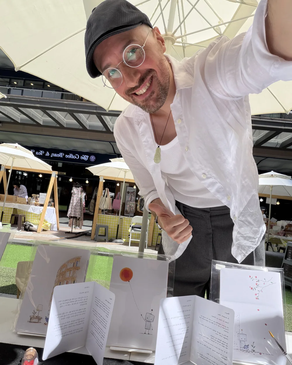 Jordan Monnet sourit derrière sa table au Maison France Festival, devant les cahiers et les lettres de Roby